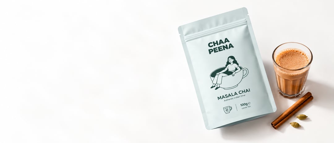Chaa Peena masala chai pouch with a glass of chai, cinnamon sticks and cardamom pods