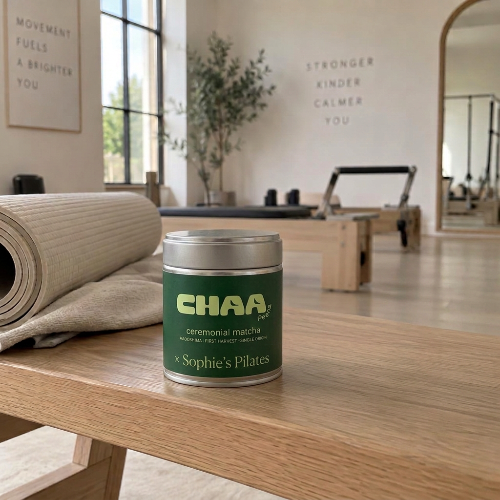 A co-branded Sophie's Pilates × Chaa Peena matcha tin in a bright Pilates studio